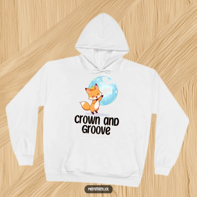 Fox wearing a crown happily bounces a giant shimmering disco ball, printed on a warm and cozy hoodie.